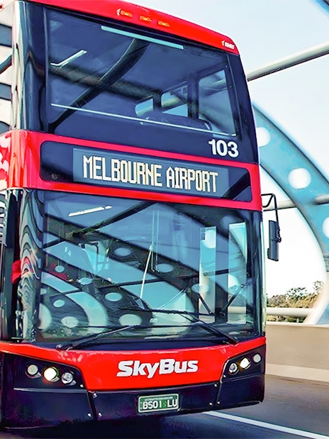 Skybus double-decker heading to Melbourne Airport on a highway bridge.