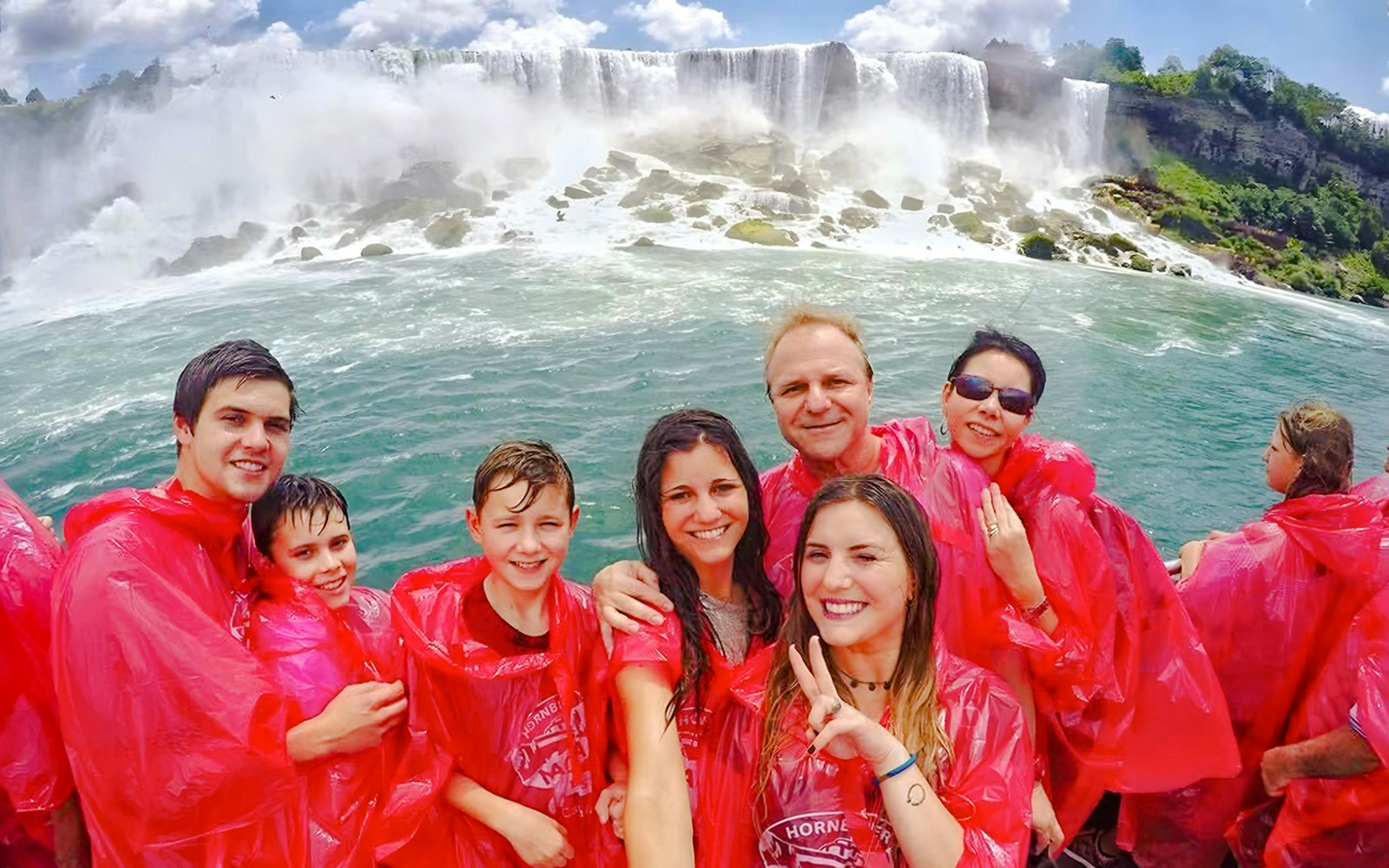 Tourists on a boat cruise near Niagara Falls, Canada, experiencing the waterfall's mist.