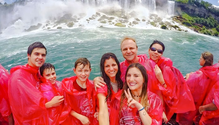 Tourists on a boat cruise near Niagara Falls, Canada, experiencing the waterfall's mist.