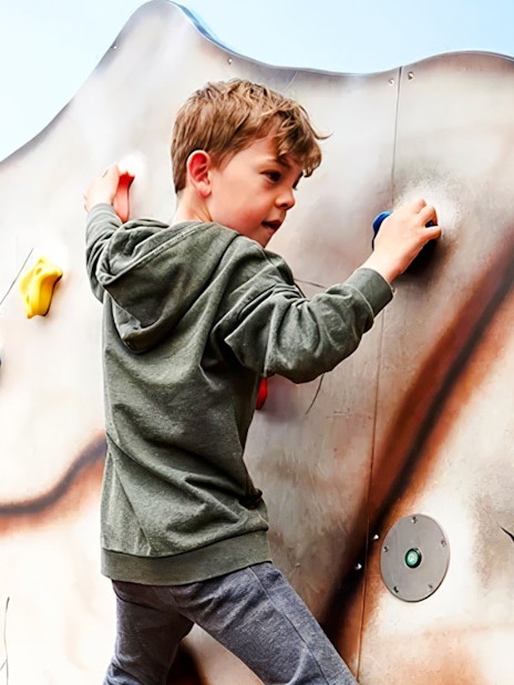 Child climbing a colorful rock wall at LEGOLAND Billund.