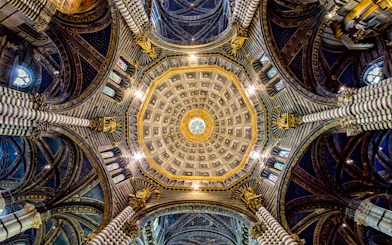 Siena Cathedral dome with intricate gold and blue designs, Italy.