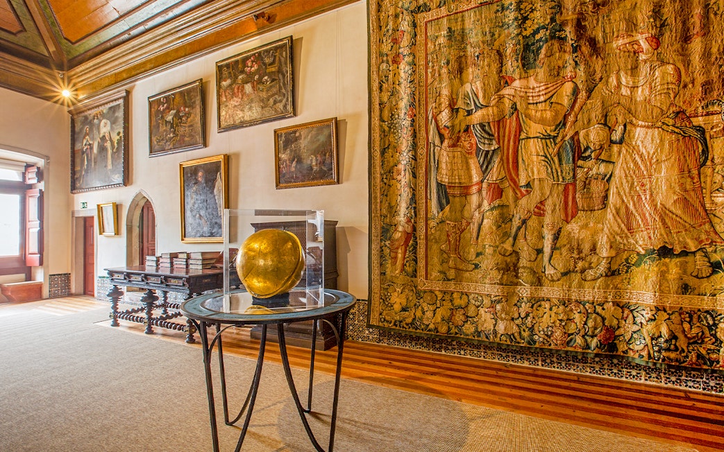 National Palace of Sintra Camarim with tapestries and paintings displayed.