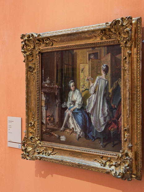 Paintings on display at the Thyssen Museum, featuring ornate frames and historical scenes.