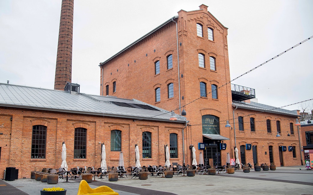 Historic brick building with outdoor seating in Warsaw, Poland.