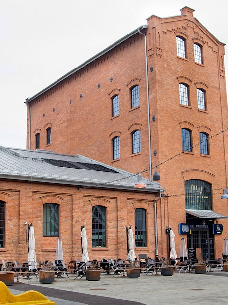 Historic brick building with outdoor seating in Warsaw, Poland.