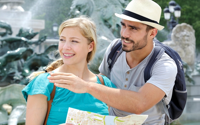 Tourists with a map exploring Somme battlefields on a day trip from Paris.