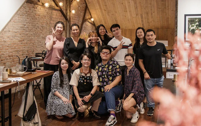 Group enjoying Vietnamese coffee workshop in rustic setting.