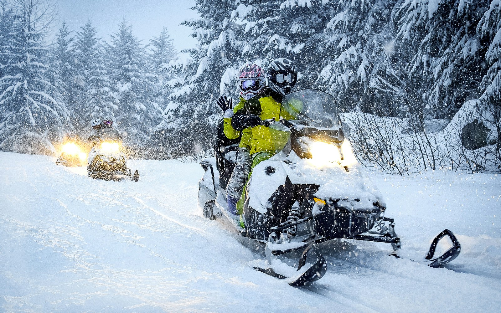 Guests riding snowmobiles through snowy forest in Zakopane.