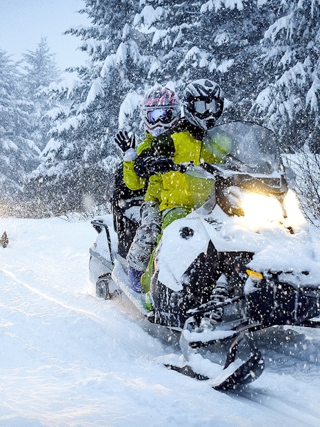 Guests riding snowmobiles through snowy forest in Zakopane.