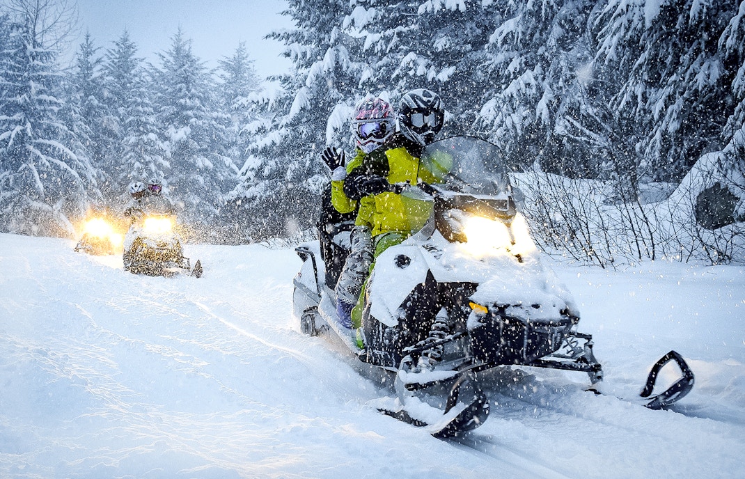 Guests riding snowmobiles through snowy forest in Zakopane.