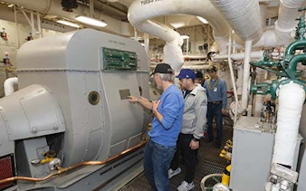 Visitors exploring machinery on a guided engineering tour.