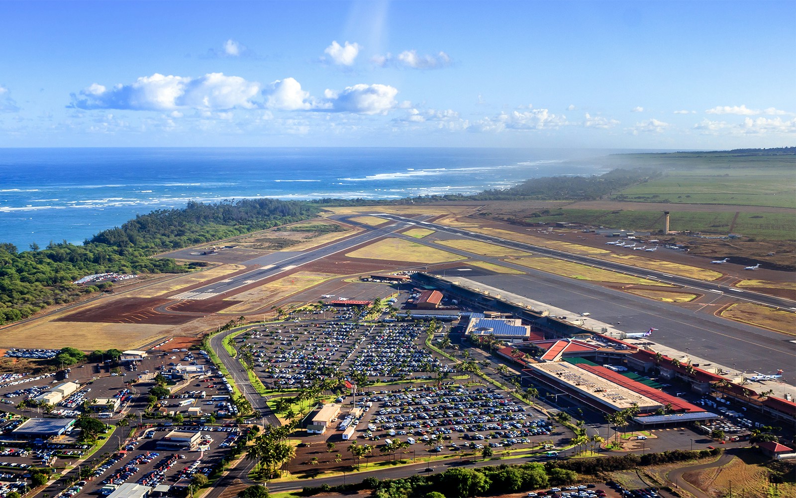 Aerial view of Kahului Heliport, Hawaii with runways and ocean backdrop.