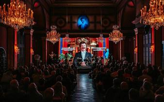 Classical concert in Vienna with musicians performing under chandeliers in an ornate hall.