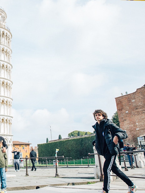 Tourists posing near the Leaning Tower of Pisa, Italy.