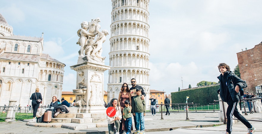 Tourists posing near the Leaning Tower of Pisa, Italy.