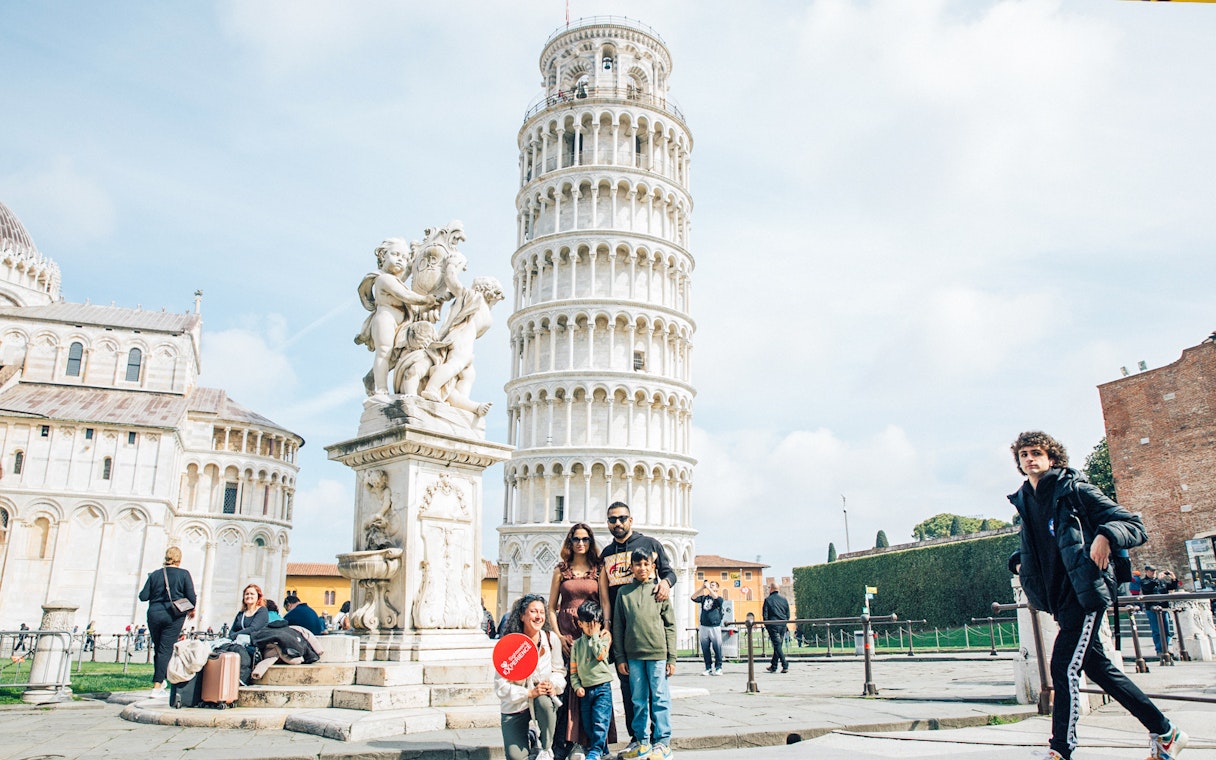 Tourists posing near the Leaning Tower of Pisa, Italy.