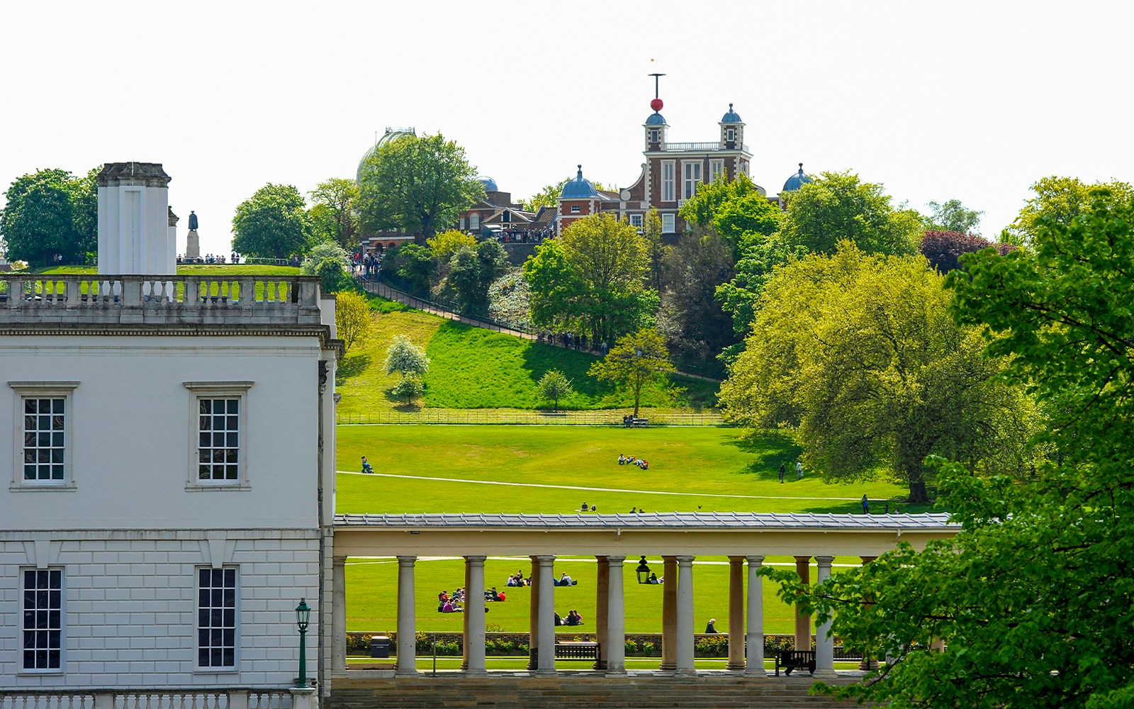 Observatorio Real de Greenwich con visitantes que exploran el histórico emplazamiento londinense.