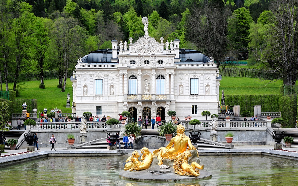 Linderhof Palace exterior with golden fountain statues in Bavaria, Germany.