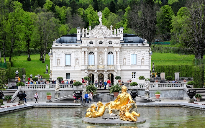 Linderhof Palace exterior with golden fountain statues in Bavaria, Germany.