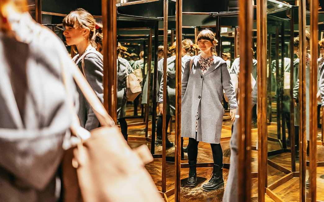 Visitor exploring mirror room at Leonardo Interactive Museum, Florence.