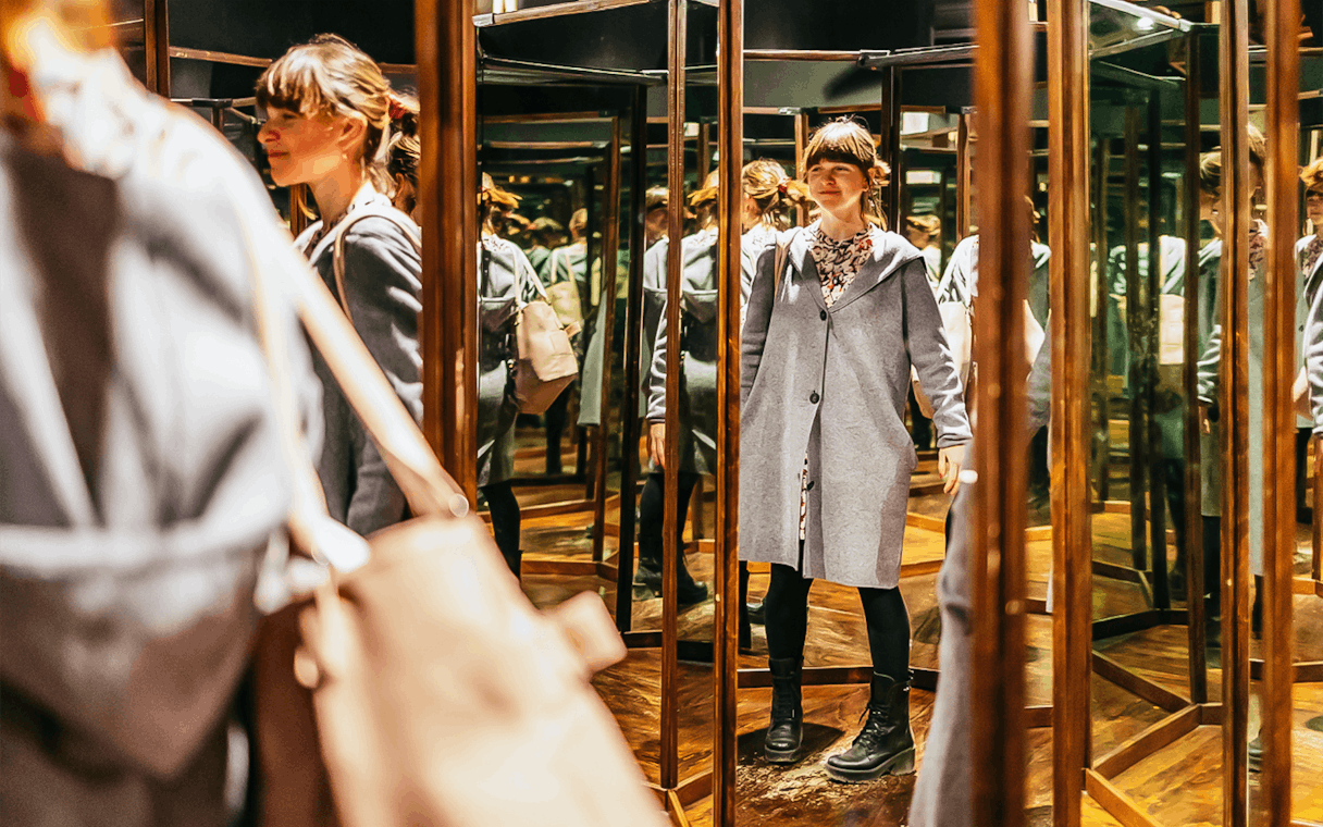 Visitor exploring mirror room at Leonardo Interactive Museum, Florence.