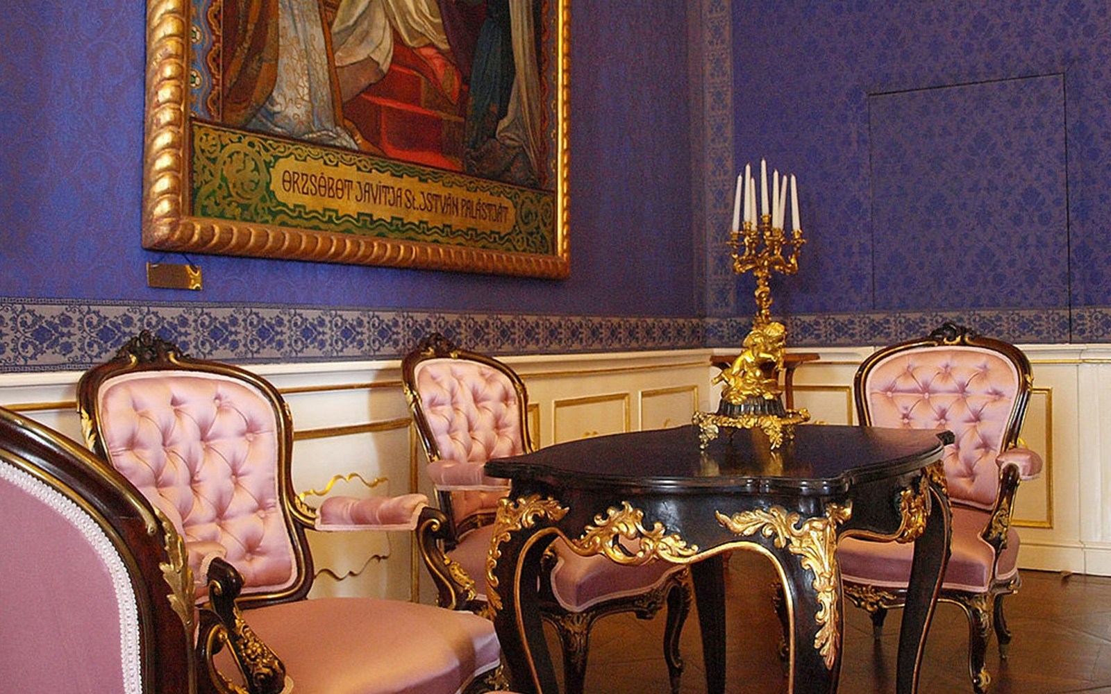 Gödöllő Royal Palace interior with ornate chairs and table.