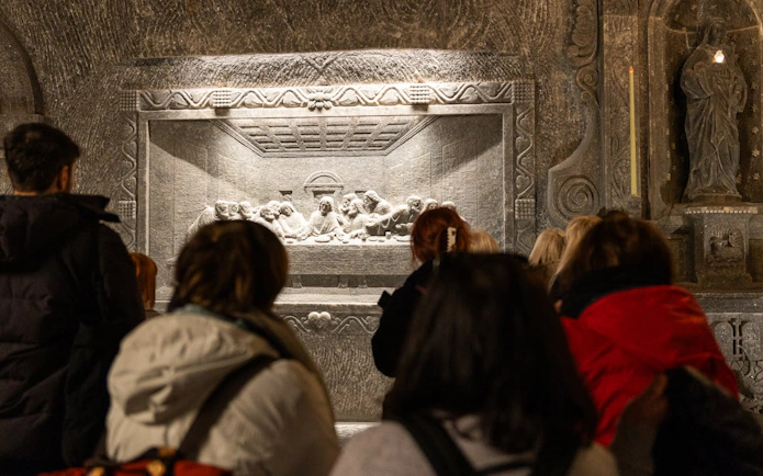 Visitors viewing a salt carving of the Last Supper in Wieliczka Salt Mine, Poland.