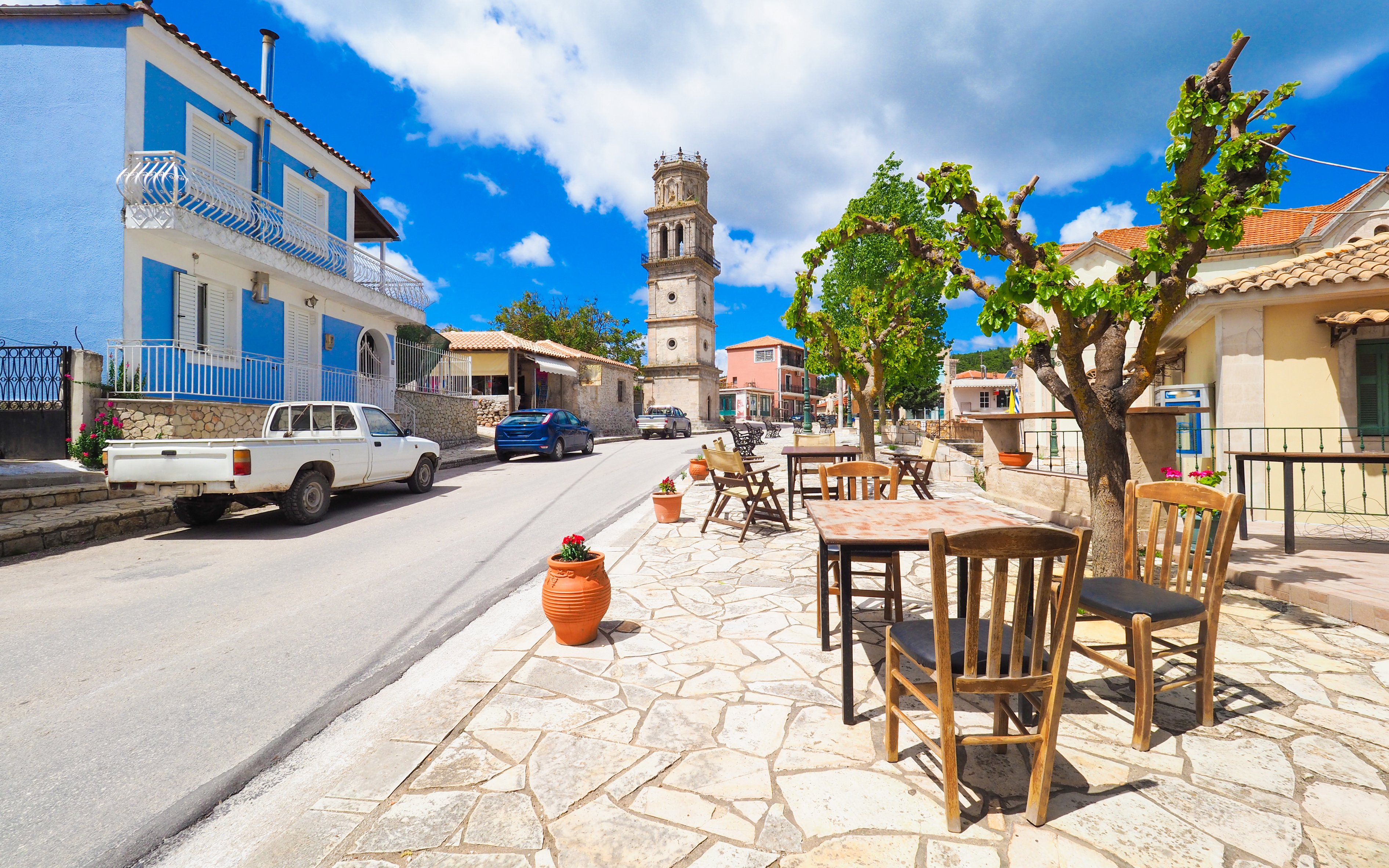 Street view with outdoor seating and bell tower in Zante, Greece.