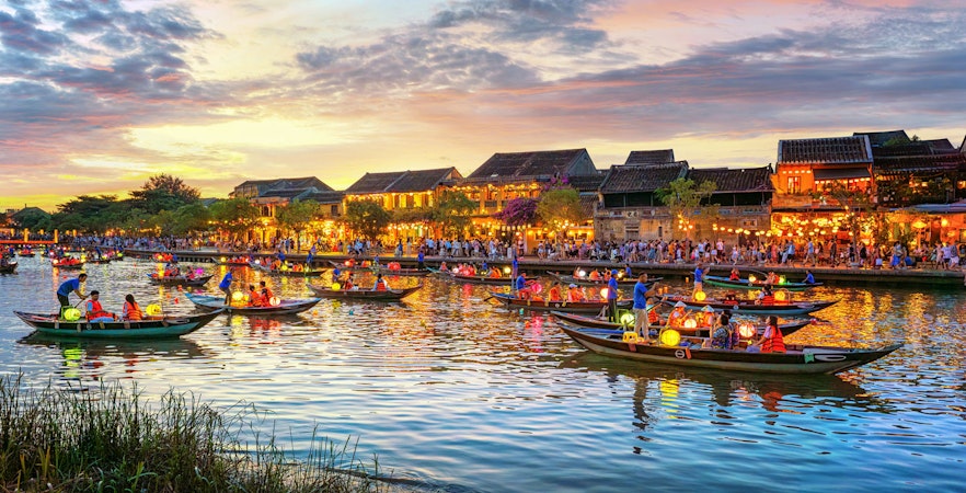 Long-tail boats with Vietnamese lanterns on the river in Hoi An, Vietnam at sunset.