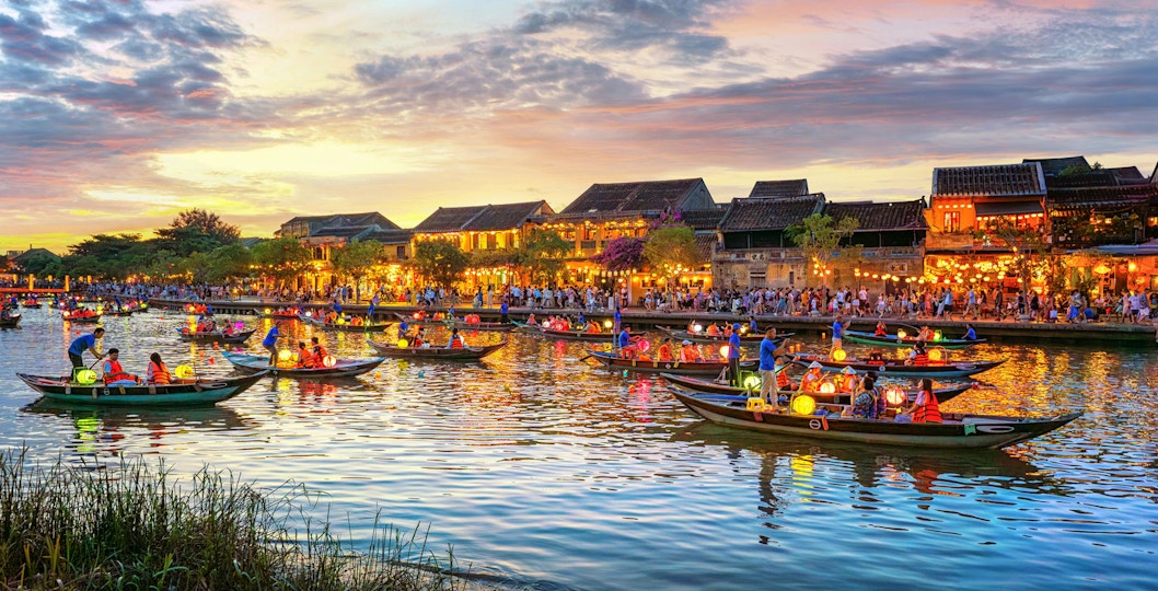 Long-tail boats with Vietnamese lanterns on the river in Hoi An, Vietnam at sunset.