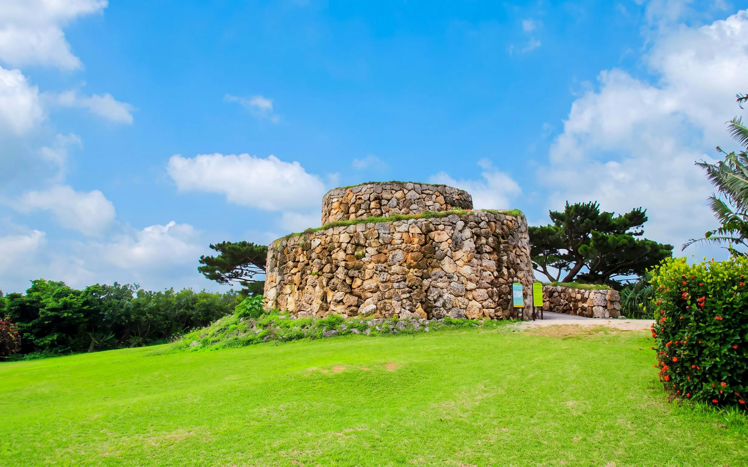 Stone structure in Ishigaki Yaima Village surrounded by greenery and trees.