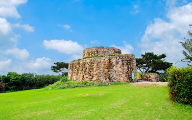 Stone structure in Ishigaki Yaima Village surrounded by greenery and trees.