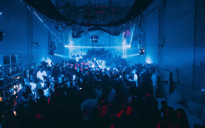 Crowded dance floor with blue lighting at Supperclub nightclub in Amsterdam.