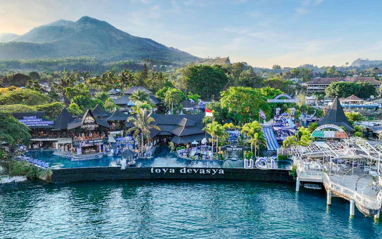 Aerial view of Toya Devasya Hot Spring Waterpark with Mount Batur in the background, Bali.
