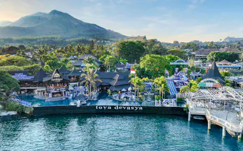 Aerial view of Toya Devasya Hot Spring Waterpark with Mount Batur in the background, Bali.