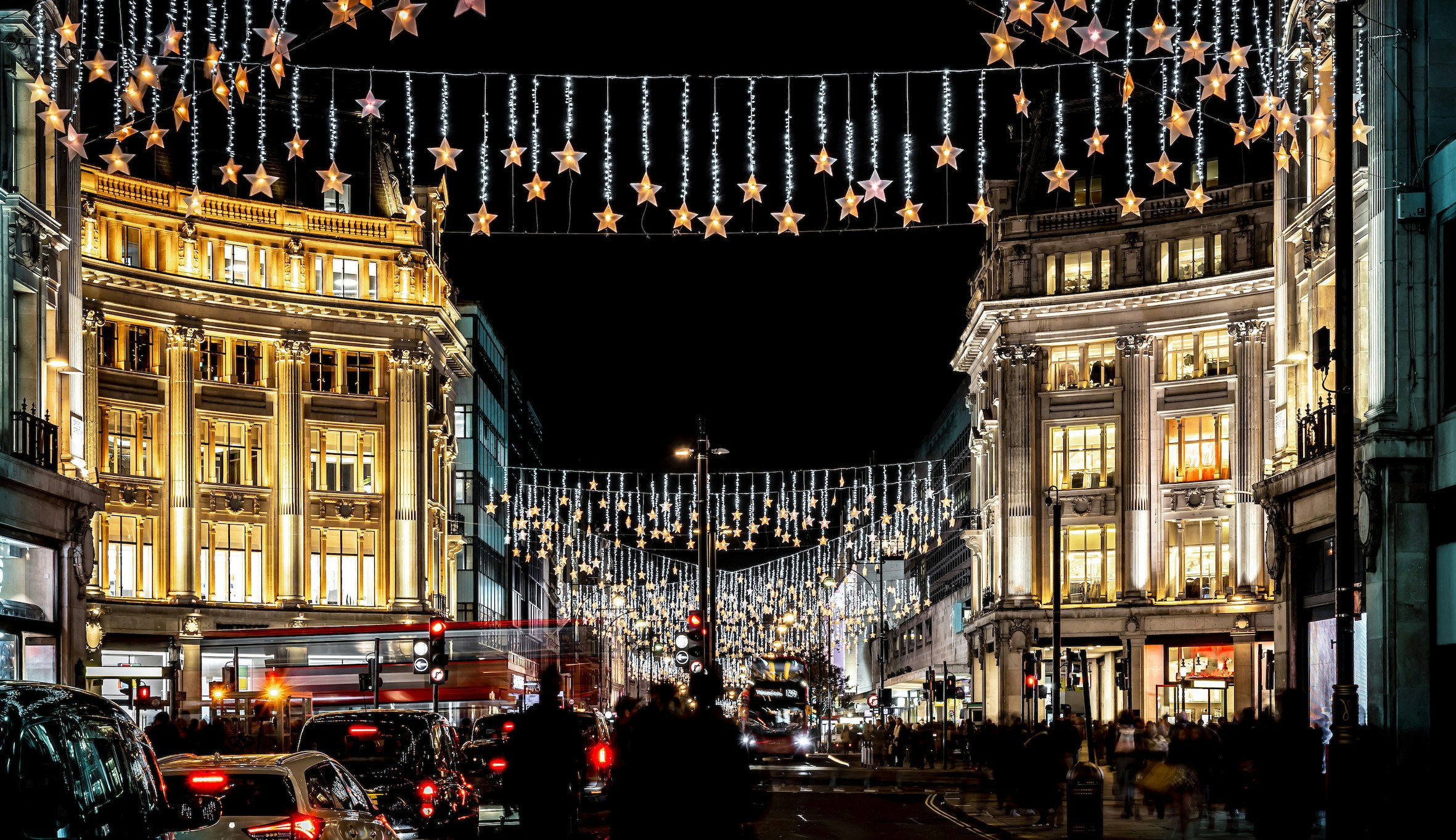 Oxford Street in London adorned with Christmas lights and bustling evening traffic.