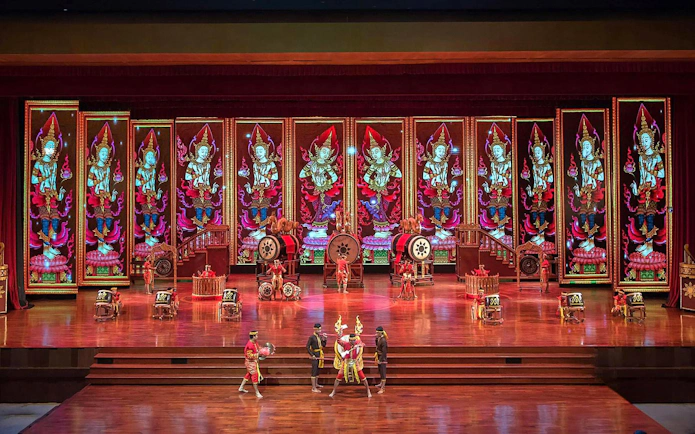 Traditional Thai performance at Nong Nooch Tropical Garden stage with vibrant backdrop.