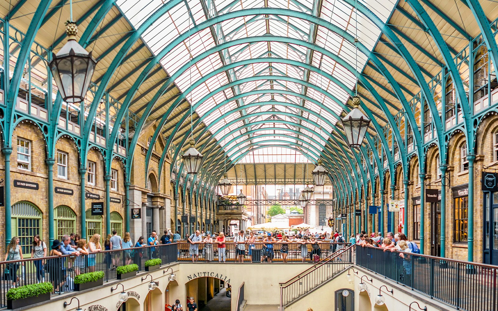 Touristes explorant le vibrant marché de Covent Garden à Londres, qui présente des étals uniques et une atmosphère animée.