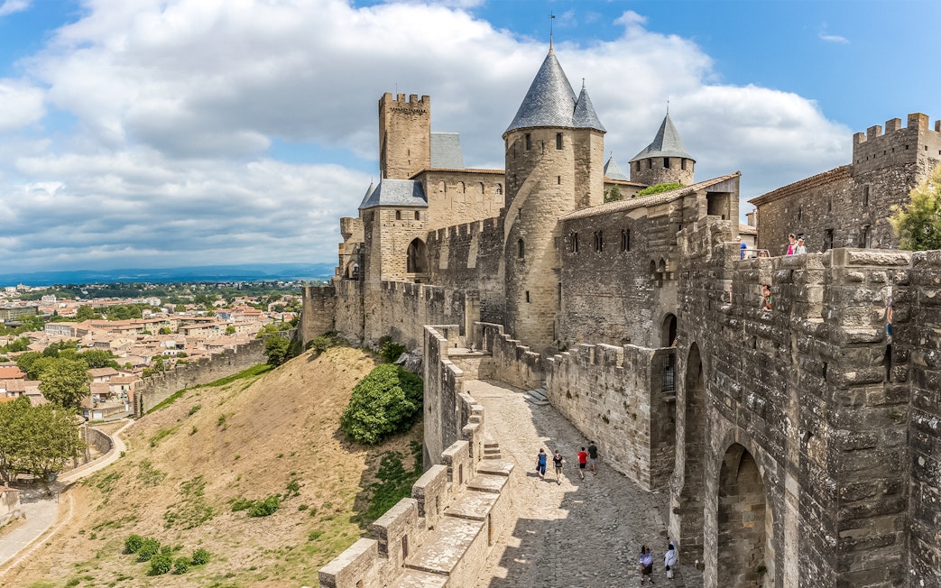 Tourists walking along the walls of Carcassonne Castle, France.