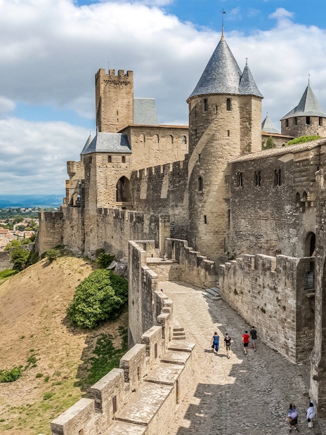 Tourists walking along the walls of Carcassonne Castle, France.