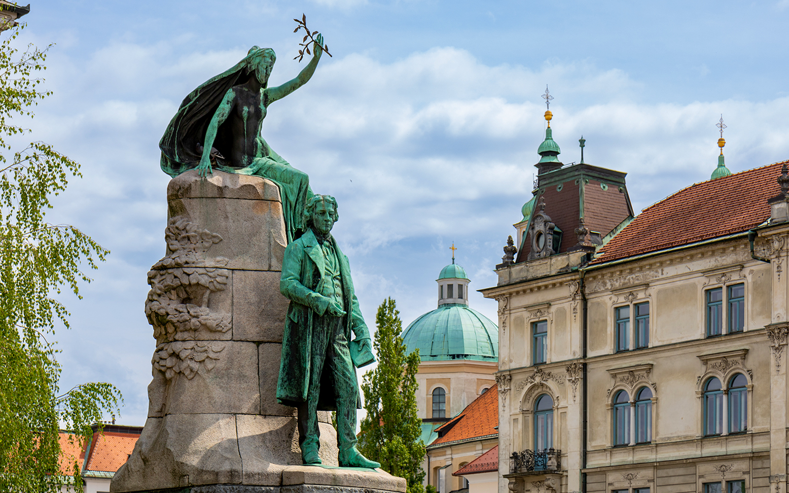 Sculpture of France Prešeren in Prešeren Square, Ljubljana with historic buildings.