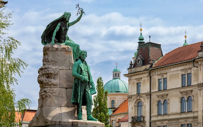 Sculpture of France Prešeren in Prešeren Square, Ljubljana with historic buildings.