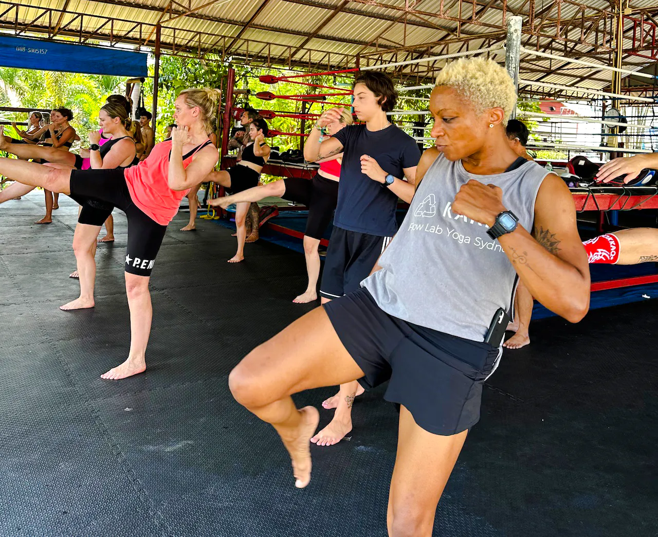 Beginners practicing Muay Thai kicks in a Phuket training class.