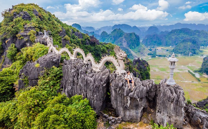 Dragon statue on rocky peak at Hang Mua viewpoint, Vietnam.