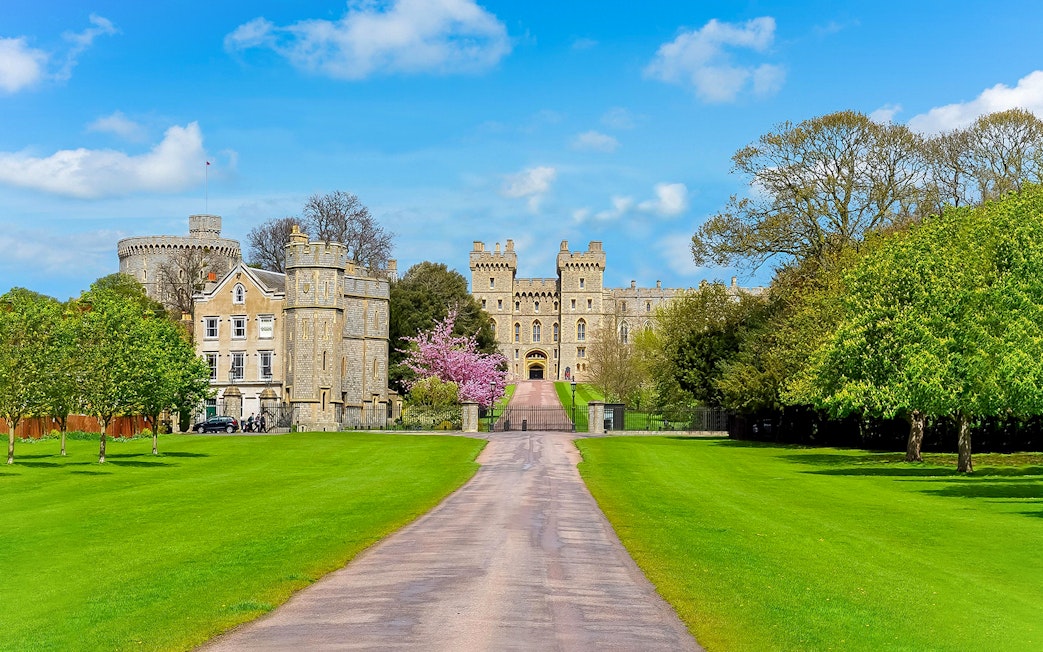 Windsor Castle entrance with lush green lawns and historic architecture.