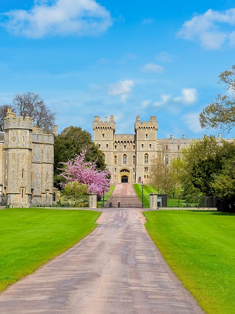 Windsor Castle entrance with lush green lawns and historic architecture.