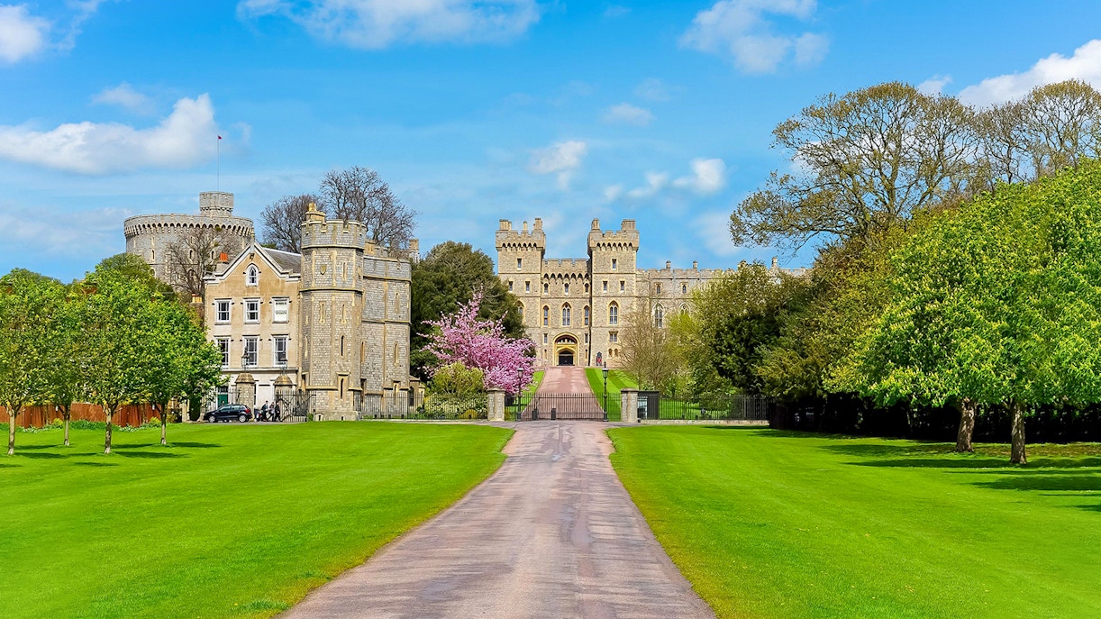 Windsor Castle entrance with lush green lawns and historic architecture.