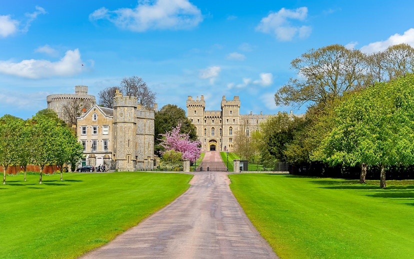 Windsor Castle entrance with lush green lawns and historic architecture.