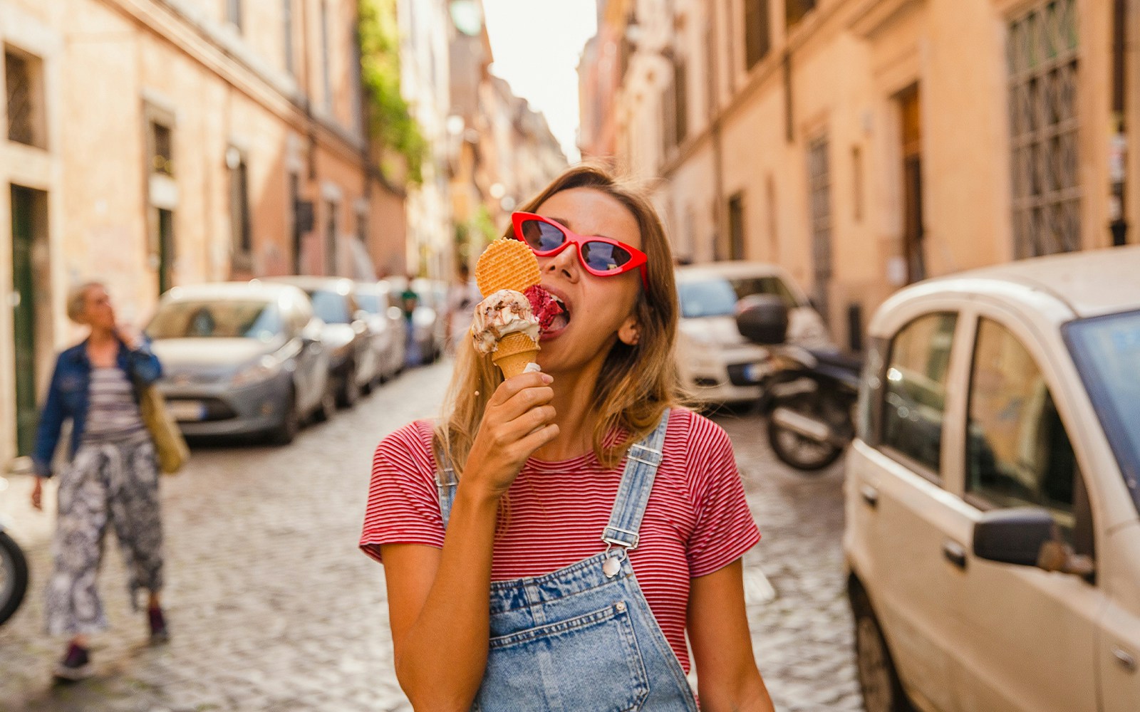 Gelato cone held in front of the Colosseum in Rome, Italy.