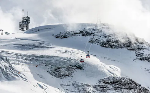 Titlis Cableways ascending snowy mountain from Engelberg, Switzerland.